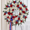 A large heart-shaped memorial wreath in red, white and blue that reads