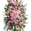 A lush standing funeral spray in pink, white and green arranged on