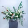 Large floral arrangement with white and peach blooms in a tall vase
