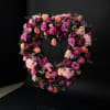 A lush heart-shaped sympathy tribute in soft lavender, blush, and pink blooms