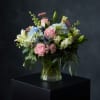 It has a soft, romantic garden feel. The blush roses, blue hydrangeas