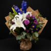 A fresh, garden-inspired bouquet featuring elegant white lilies paired with rich blue