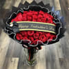 Red rose bouquet wrapped in black paper with a Valentine’s Day ribbon