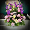Pink and purple floral arrangement with lilies in a silver urn