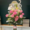 Pink roses and lilies arranged in a tall glass vase