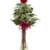 Single red rose with baby's breath in a tall clear glass vase with red ribbon bow