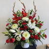 Red and white floral arrangement in a white basket vase
