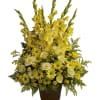 Yellow and white floral arrangement in a brown urn vase