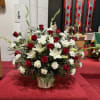 A stunning sympathy basket featuring red roses, white lilies, white carnations, baby's