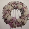 A gentle circular wreath in white, pink, lavender, and soft purple offers