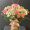 Pink roses and white daisies in a gold vase with a heart topper