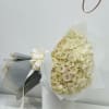 Bouquet of cream roses wrapped in white paper with a ribbon