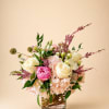 Beautiful round arrangement with a mixture of roses, spray roses, greenery, and