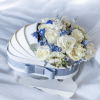 A soft cloud of creamy white roses and delicate pale blooms sits