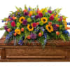 A broad, abundant spread of bright yellow sunflowers crowns this sunflower casket