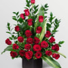 A dense cluster of velvety red roses rises from a sleek black