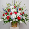 A tall, formal sympathy arrangement in a woven basket and on a
