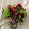 Bright green hydrangeas anchor this bold RED BEAUTY flower arrangement, their lush
