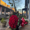 Bouquet of red roses wrapped in black paper with a red ribbon