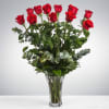 Tall bouquet of red roses in a clear glass vase
