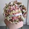 Soft pink and white roses gathered with pink lilies and delicate white-and-pink
