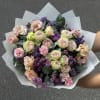 Bouquet of pale roses and pink carnations with purple filler flowers