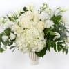 White roses and hydrangeas arranged in a clear vase