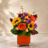 Bright orange roses and sunny yellow gerbera and sunflower heads make this