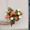 Rounded bouquet of pink, peach, white and orange roses with dark green