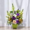 Mixed bouquet in a lime green vase with purple, white, and yellow flowers