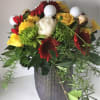 Bouquet of red, yellow, and white flowers in a textured gray vase