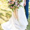 Bride holding a pastel bouquet with peach and pink roses