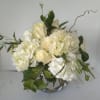 White roses and hydrangeas in a clear glass vase
