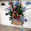 Tall mixed flower arrangement in a basket with a fishing sign