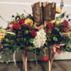 Cowboy boots surrounded by a floral arrangement of roses and lilies