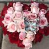 Heart-shaped bouquet of pink and red roses with a butterfly ornament
