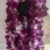 Purple orchid lei draped over a dark doorknob