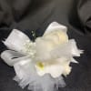 White floral wrist corsage with ribbon and tulle accents