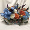 Colorful bouquet with roses, calla lilies, and hydrangeas with a blue ribbon