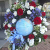 A circular wreath of red, white, blue and purple blooms encircles a