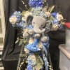 Soft clusters of vivid blue hydrangeas and cream roses form the heart