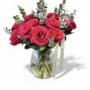 Hot pink roses arranged in a clear glass vase with eucalyptus