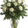 A beautiful cluster of white roses with lush green foliage arranged upright