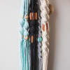 Macrame wall hangings in pastel blue, black, gray, and cream