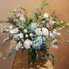 Pastel bouquet of roses, hydrangeas, and orchids in a glass vase
