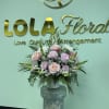 Pink and lavender roses with white snapdragons, daisies and airy greenery in