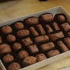 Box of assorted chocolate candies in paper cups