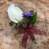 White rose boutonniere with purple accent flower and burgundy ribbon