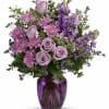 Lavender roses and purple flowers in a purple glass vase