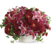Red and pink floral arrangement in a white round container